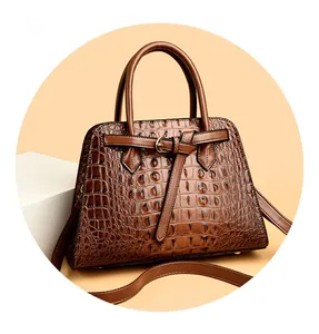 Detailed view of a brown crocodile pattern handbag with dual handles and metal strap buckles