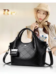 Detail of black quilted bucket bag with silver kangaroo logo and textured leather finish