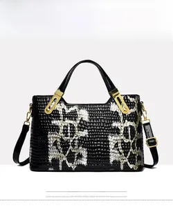 Detail of black faux crocodile skin handbag showing luxury texture and golden hardware