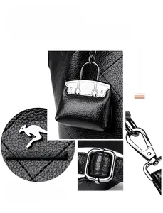 Close-up of black litchi pattern leather texture with metal logo and bucket bag charms