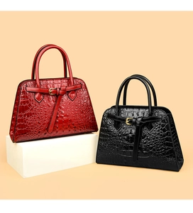 Close-up of crocodile pattern tote bags in red and black with elegant gold buckles