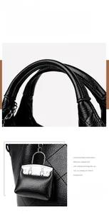 Detail of lychee pattern leather handle and a mini bag charm on a black bucket bag