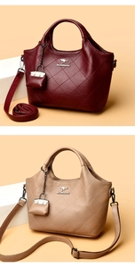Detail of quilted leather bucket bags in burgundy and beige with fine stitching