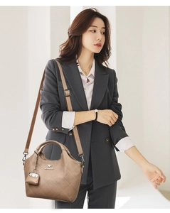 Close-up of khaki quilted leather bucket bag with top handles and adjustable strap