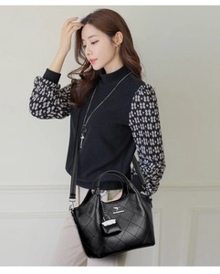 Detail of black quilted bucket bag with gold kangaroo logo and matching mini pouch