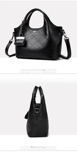 Macro view of black quilted leather bucket bag with silver logo and mini coin purse charm