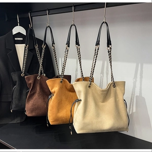Detail of four drawstring bucket bags in suede-like finish with metal chain straps