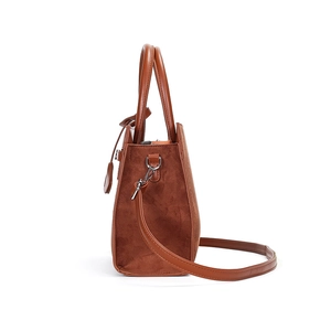 Caramel brown suede handbag with leather straps and silver hardware in side profile