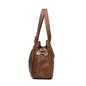 Brown faux leather tote bag with dual handles and ornate metal zipper details