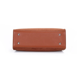 Brown leather handbag bottom with four protective silver metal studs on white background
