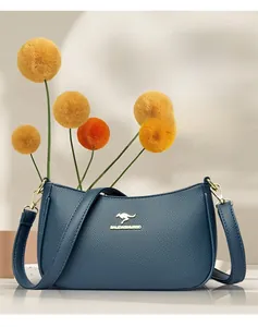 Dettaglio ravvicinato della borsa a tracolla in pelle blu martellata con logo dorato