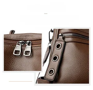 Dettaglio dello zaino in pelle marrone con doppia cerniera e occhielli in metallo lucido