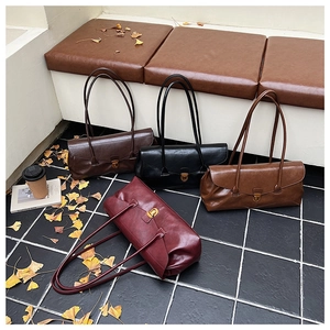 Retro shoulder bags in burgundy and brown leather on floor with autumn leaves