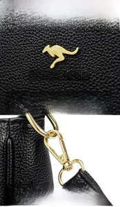 Dettaglio logo a canguro dorato e tracolla rimovibile su borsa in pelle litchi nera