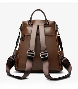 Dettaglio dello zaino in pelle marrone scuro con spallacci e tasca posteriore con zip