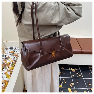 Close-up of vintage dark brown leather shoulder bag with metallic twist lock detail