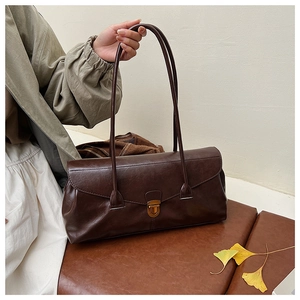 Detail of vintage coffee brown shoulder bag with antique bronze buckle and leather texture