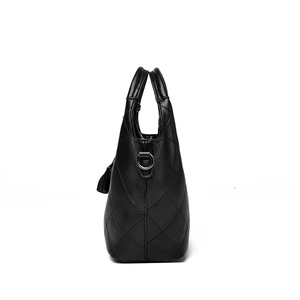 Classic black quilted leather bucket bag with top handles and tassel decoration