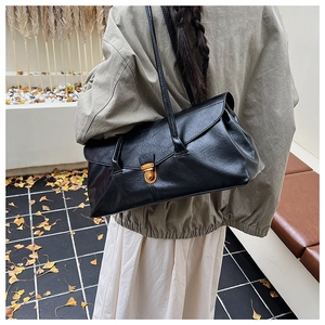 Detail of vintage black leather shoulder bag with bronze clasp and autumn vibe