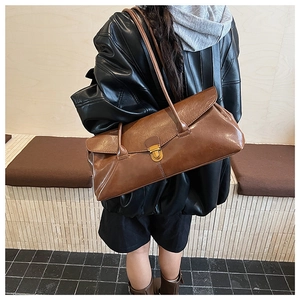 Close-up of a vintage brown leather shoulder bag featuring a sleek gold metal buckle