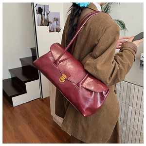 Detailed back view of vintage burgundy baguette bag with gold metal buckle on shoulder