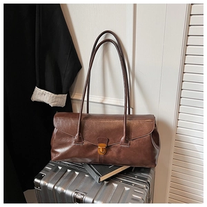 Detail of dark brown retro baguette bag with oil-wax leather texture and metal buckle