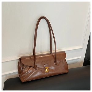 Macro detail of brown leather baguette bag with elegant gold push-lock buckle