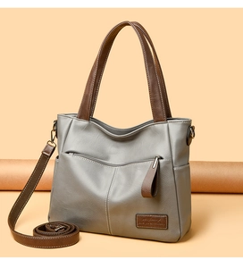Detail der dunkelgrauen Shopper-Tasche mit braunen Henkeln und feiner Lederstruktur