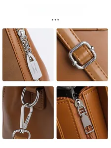 Detailed view of silver metal zipper and hardware on a brown leather handbag