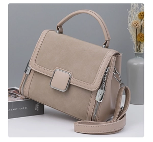 Detail of beige tote bag featuring mixed textures with silver hardware and chain strap