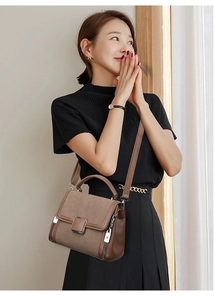 Detail view of the elegant brown patchwork handbag with metal zipper and silver hardware