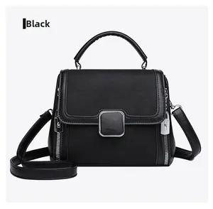 Black matte leather bag with silver buckle and side zipper details on white background