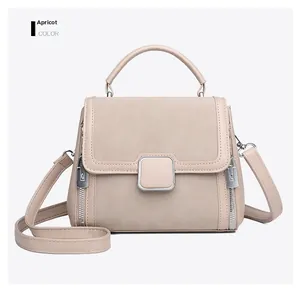 Detail of apricot handbag featuring mixed leather textures and silver metal buckle