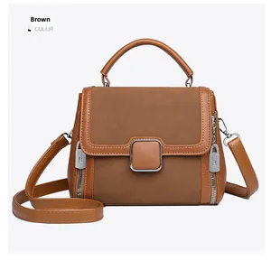 Detailed view of brown handbag with leather splicing and square metal buckle