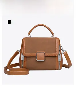 Front view of vintage tan matte leather handbag with silver lock and magnetic buckle