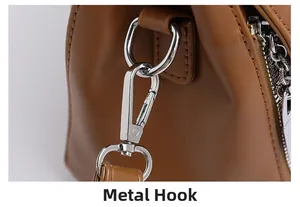 Detail of metal hook on a caramel brown leather handbag with fine stitching