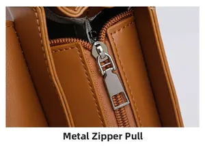 Detail view of brown textured faux leather handbag showing premium silver metal zipper pull