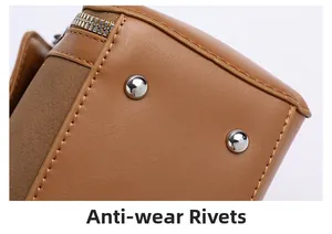 Close-up of silver anti-wear rivets and metal zipper on brown faux leather handbag