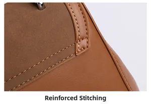 Detail of reinforced stitching on brown leather and suede paneling of the fashion handbag