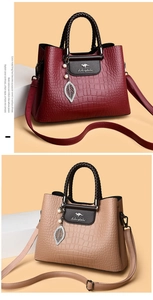 Détail de sacs cabas en cuir gaufré bordeaux et beige avec breloques perles