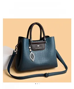Détail du sac à main bleu marine en cuir gaufré crocodile avec breloques perles