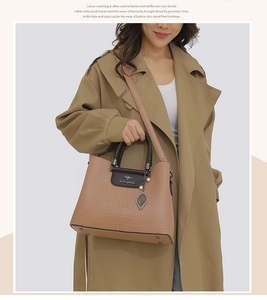Détail du sac à main en cuir embossé abricot avec logo métallique et bandoulière chic