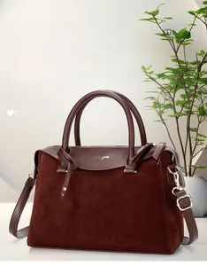 Detail of burgundy leather Boston bag with metallic F pendant and gold hardware