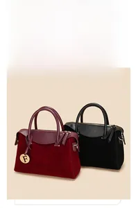 Detail of color-block Boston handbags in burgundy and black with gold F pendants
