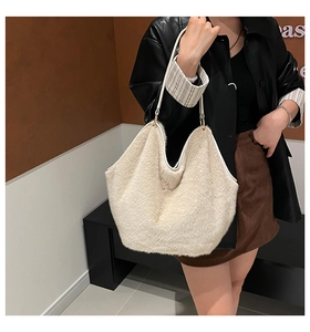 Close-up of fluffy off-white faux fur tote bag with golden metal rings and thin shoulder straps