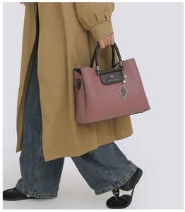 Détail du sac à main rose poudré avec poignée tressée et pendentif perle en feuille