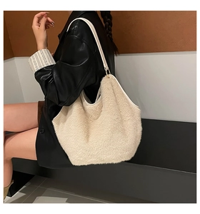 Close-up of white faux fur tote bag with leather straps and gold metal ring detail