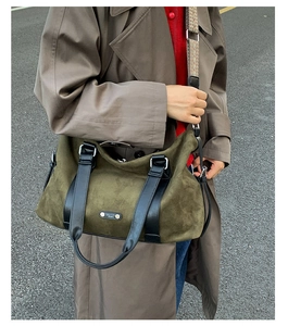 Detail of vintage olive green tote bag with ethnic patterned strap on pavement