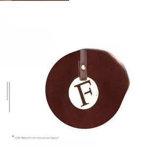 Detail of round metal clasp with F-embossing on dark brown suede boston handbag