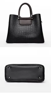 Vue détaillée du sac en cuir gaufré crocodile noir avec poignées tressées et clous de fond